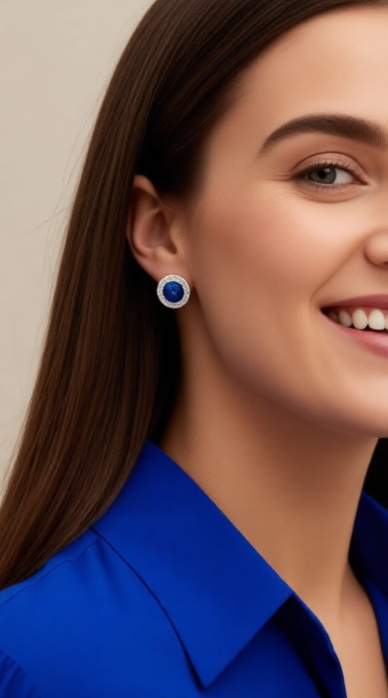 Zilveren solitaire blauwe oorbellen omgeven door stenen