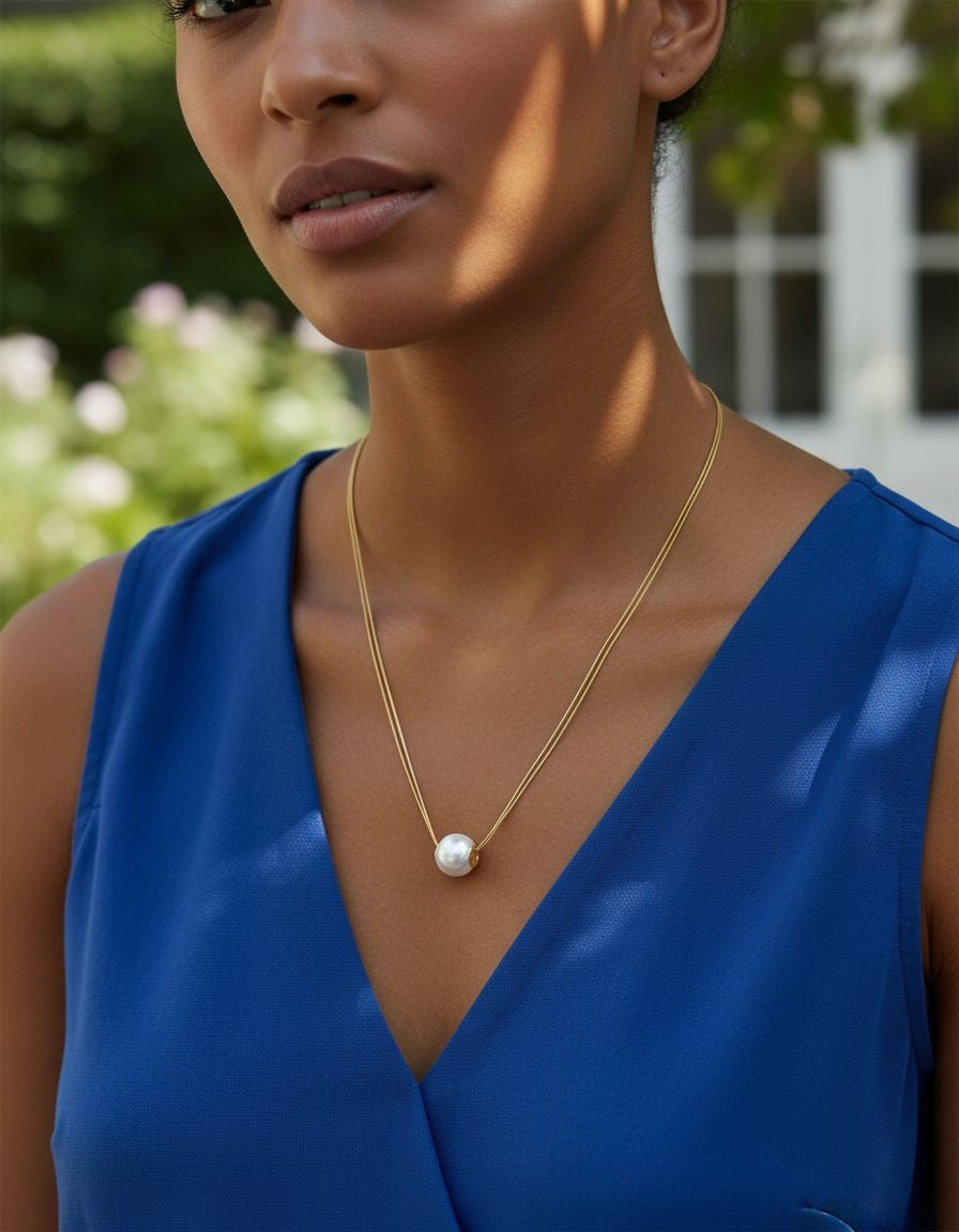 COLLIER EN ACIER DORE A DOUBLE MAILLE ORNE D'UNE PERLE CENTRALE