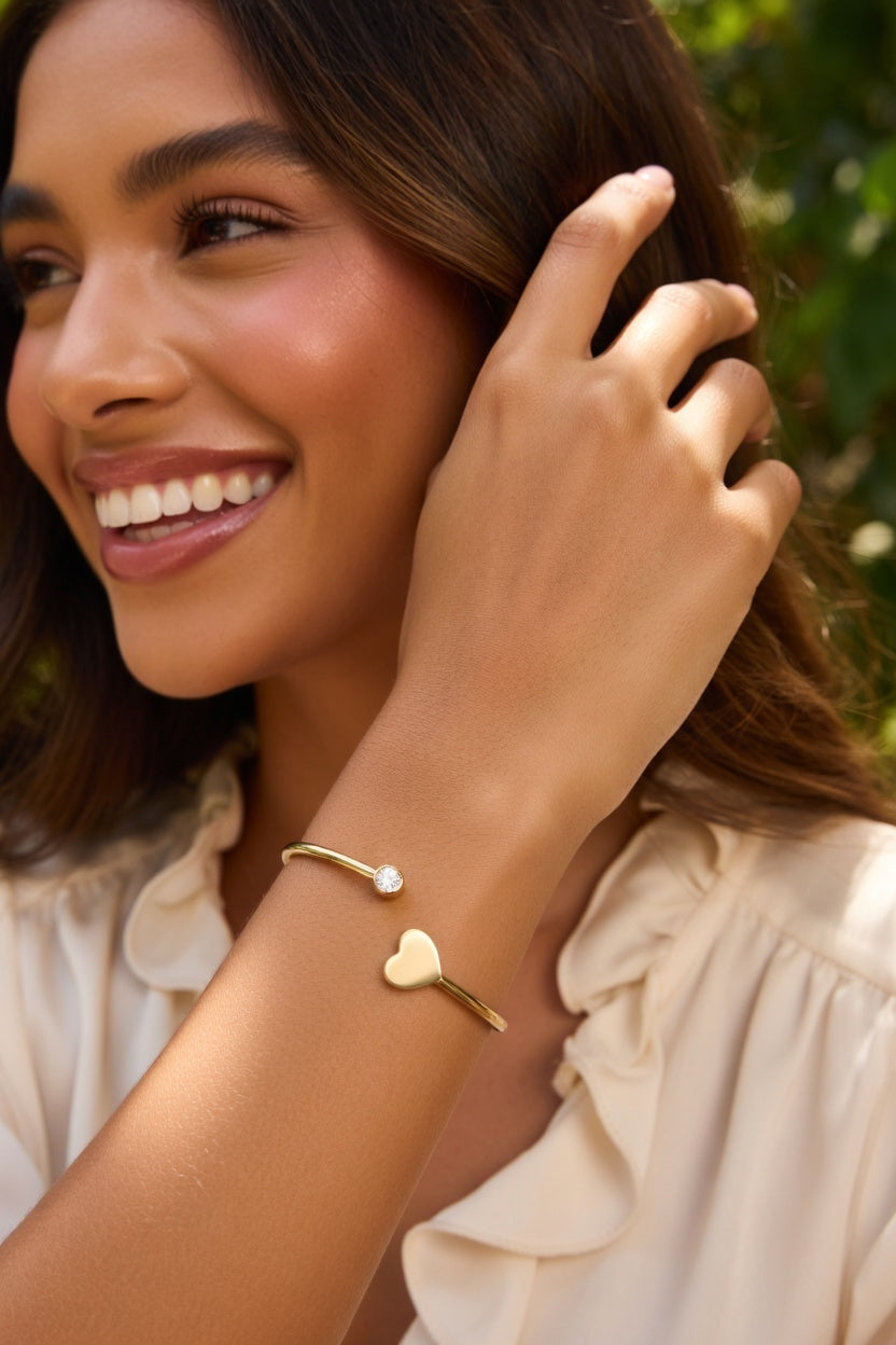 Stijve vergulde stalen armband met hart en strass steentjes